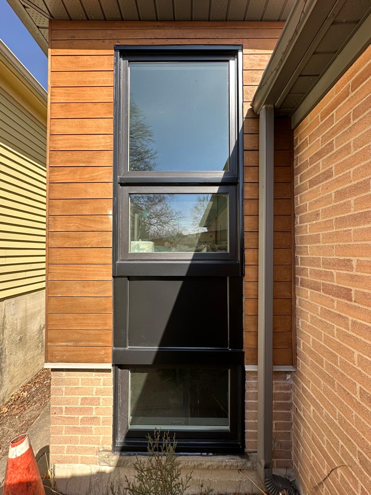Black-frame windows on a modern wood-clad exterior