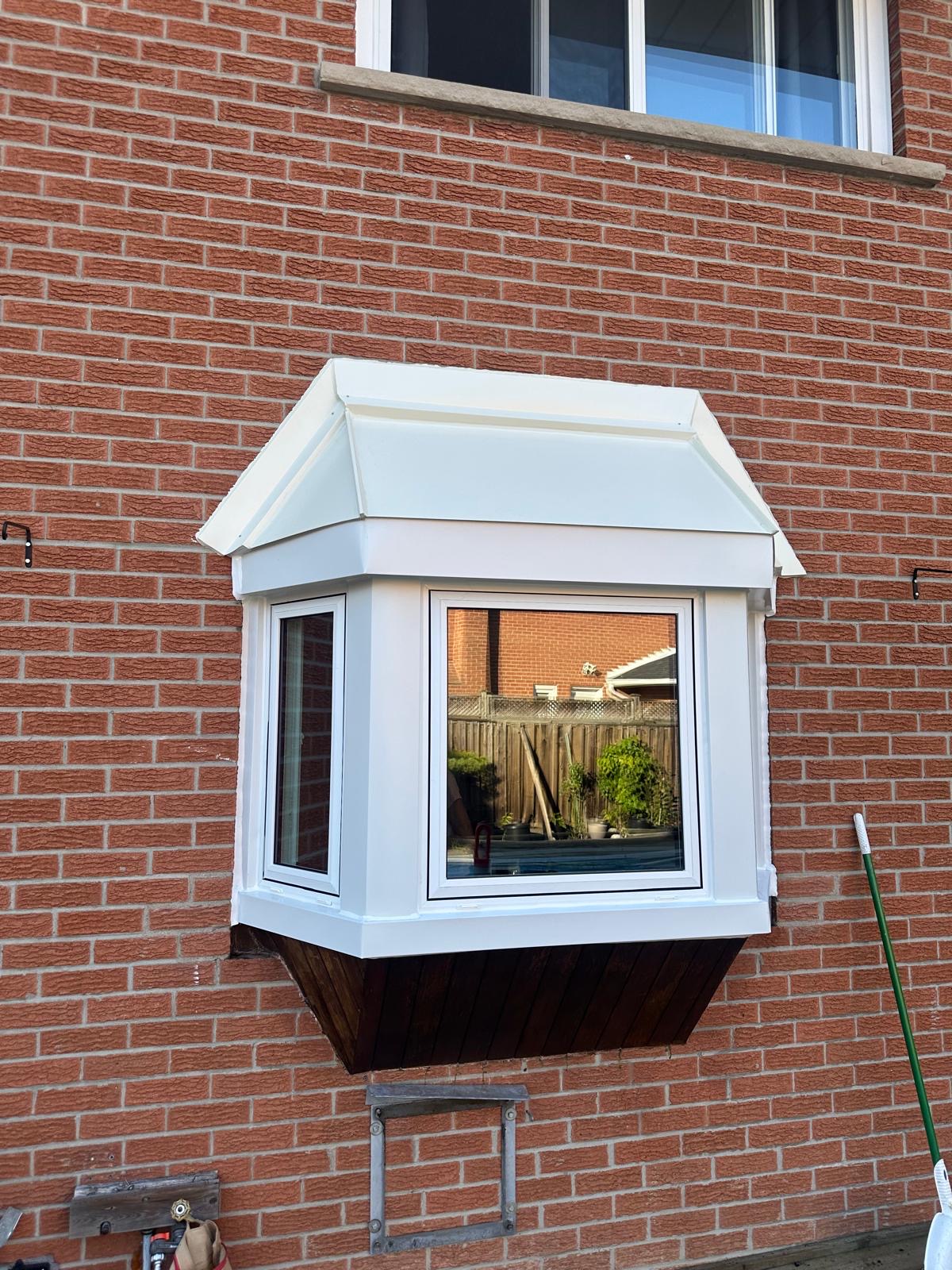 Bay window with white capping on a red brick house